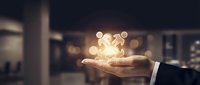 Businessman holding glowing light bulb in palm, symbolizing innovation, creativity, and bright ideas for business solutions and entrepreneurial success.