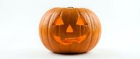 Carved orange pumpkin jack-o-lantern with glowing triangular eyes and smiling mouth isolated on white background for Halloween decorations and autumn designs.