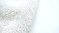 Soft white fluffy fur texture close-up with long silky fibers creating luxurious cozy background for interior design and fashion projects.