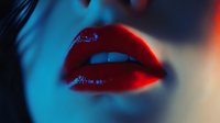 Sensual close up of glossy red lips in dramatic blue lighting, creating mysterious and seductive mood. Professional makeup artistry showcases perfect application and shine.