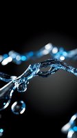 Dynamic stream of blue-tinted water with droplets splashing against dark background, creating elegant curves and bokeh light effects in macro photography.