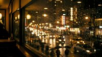 Raindrops on window glass with blurred city lights and buildings at night, urban bokeh background for nighttime, weather, and cityscape design projects.