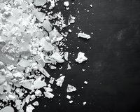White crystalline substance scattered on dark slate background, creating stark contrast between light and dark elements for culinary or scientific context.