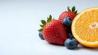 Fresh mixed berries and orange slice on white background for healthy eating and nutrition concepts.