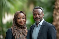 Professional African American father and daughter portrait outdoors with natural green foliage background for family photography and lifestyle content.