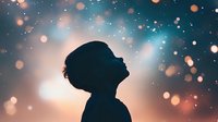 Silhouette of young woman looking up at magical bokeh lights against dreamy turquoise and orange sky background, expressing wonder and hope.