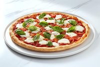 Fresh Margherita pizza with melted mozzarella, tomato sauce and basil leaves on white ceramic plate against marble background, appetizing Italian cuisine.