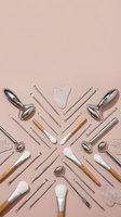 Facial massage tools and acupuncture needles arranged in geometric pattern on pink background for skincare and wellness treatments.