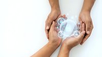Male hands of South Asian descent holding a globe with water droplets, symbolizing environmental conservation, sustainability, and global responsibility for water protection and eco-friendly initiatives.