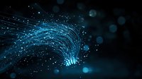 Glowing blue fiber optic strands emit light against dark background with bokeh effects, creating futuristic technology concept for digital communications.