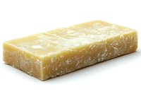Block of aged parmesan cheese with crystalline texture and natural rind showing authentic dairy craftsmanship, isolated on white background for culinary and food packaging.
