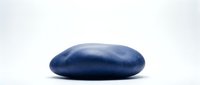 Smooth blue oval stone or pebble isolated on white background for zen meditation, spa wellness, balance and natural decoration concepts.