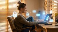 Young woman working on laptop with digital security icons floating around screen, representing cybersecurity, data protection and online safety concepts.