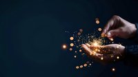 Male hands holding magical golden light particles against dark blue background, creating an atmosphere of wonder and innovation.