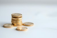 Stack of golden coins on white background, symbolizing wealth, savings and financial success. Clean minimalist composition for business and finance concepts.