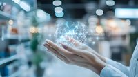 Digital network sphere floating above female hand in white sleeve, glowing with futuristic connections against blurred modern office background with bokeh lights.