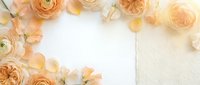 Elegant peach and cream roses with ranunculus flowers frame white paper on textured background for wedding invitations and romantic stationery designs.