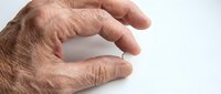 Senior adult hand with wrinkled skin and age spots gesturing pinch or small size measurement against white background for healthcare, aging, or medical concepts.