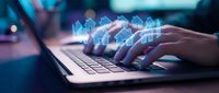 Hands typing on laptop with glowing digital house icons floating above keyboard representing smart home technology and real estate innovation.