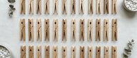 Wooden clothespins arranged in neat rows on white background, perfect for laundry organization, crafts, and home decoration projects.