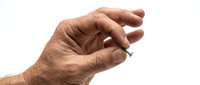 Senior male hand with wrinkled skin gesturing pinch or small size measurement isolated on white background for healthcare, aging, arthritis or size comparison concepts.