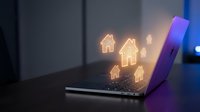 Modern laptop displaying glowing house icons on screen representing digital real estate technology and online property management solutions.