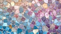 Colorful mosaic pattern made of natural stone pieces in pink, blue, and purple tones creating an abstract decorative surface texture for interior design.