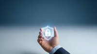 Caucasian male hand holding glowing shield icon with security lock symbol, representing data protection, cybersecurity, and digital safety solutions for business and technology concepts.