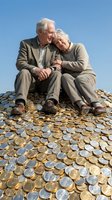 Happy senior couple sitting on pile of coins representing retirement savings and financial security under clear blue sky.