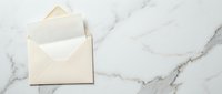 Cream envelope with blank white card on elegant marble surface for wedding invitations, greeting cards, and stationery design projects.