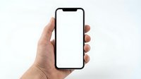 Hand holding modern smartphone with blank white screen mockup for app presentation and mobile interface design projects.