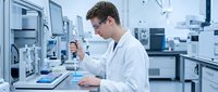 Young male scientist in white lab coat conducting research with pipette in modern laboratory facility for pharmaceutical and biotechnology applications.