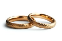 Pair of textured gold wedding bands with hammered finish isolated on white background, suitable for jewelry marketing, wedding websites, and e-commerce design.