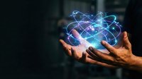 Hands holding glowing atomic structure with orbiting electrons, representing science, physics, nuclear energy, molecular research and scientific innovation concepts.