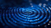 Mesmerizing blue ripples with glowing particles create concentric circles against dark background, abstract macro photography for modern tech designs.
