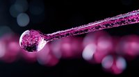 Frozen water droplet on branch with pink bokeh background creates magical winter macro photography moment, highlighting nature's delicate crystalline formations.