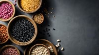 Assorted legumes and beans in wooden bowls on dark background. Healthy protein-rich foods including lentils, chickpeas, kidney beans for cooking and nutrition.