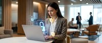 Young professional businesswoman working on laptop with cybersecurity interface in modern office environment, data protection and digital security concept.