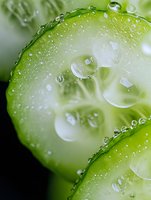 Fresh cucumber slices with water droplets macro photography for healthy eating and spa wellness concepts in natural green tones.