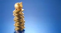 Golden piggy bank sitting on top of tall stack of coins against blue gradient background representing savings growth and financial planning.