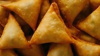 Golden fried samosa pastries with crispy exterior, traditional Indian appetizer snack food for restaurants, catering, cuisine menus.