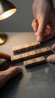 Male hands arranging wooden letter blocks spelling quality, compliance, and audit on gray surface under desk lamp for business concepts.
