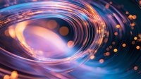 Glowing spiral light trails with orange and blue luminous effects create dynamic motion against dark background, abstract cosmic energy pattern.