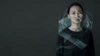 Young woman with fair skin and dark hair wearing black clothing against dark gray background, surrounded by glowing turquoise digital wave patterns and light effects, representing technology, innovation, and digital transformation concepts.