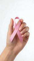 Female hand holding pink ribbon symbol for breast cancer awareness campaign and women health support on white background.