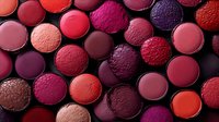 Colorful lipstick collection in various shades of red, pink, purple and coral arranged in circular pattern for beauty and cosmetics industry.