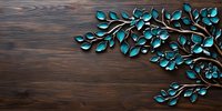 Metallic turquoise branch with leaves on dark wooden background, decorative wall art piece featuring nature-inspired design elements. Modern home decor composition.