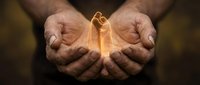 Cupped hands holding glowing golden gift box with ribbon, magical light emanating from present, generosity and giving concept for holidays and special occasions.