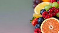 Fresh mixed berries and citrus fruits arrangement with strawberries, blueberries, red currants, orange and lemon slices for healthy eating and nutrition.