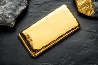 Shiny gold bar on dark stone background with rough mineral rocks. Luxury investment and precious metal concept for banking and wealth management.
